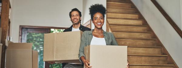 two people carry boxes moving property