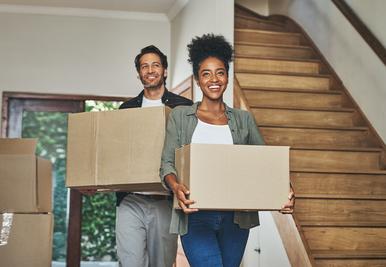 Two people holding boxes moving property