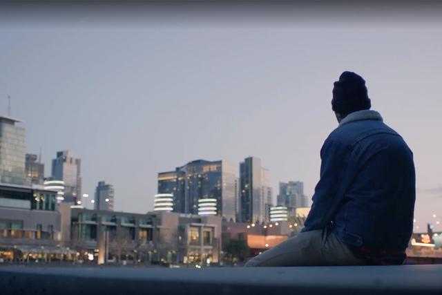 Young man looks over skyline of houses in housing crisis.
